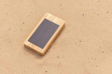Pruun Sunwick 10 000 mAh bambusest päikeseakupank — detailne perspektiivvaade puidust pinnal, logoga personaliseeritav, Logo.ee