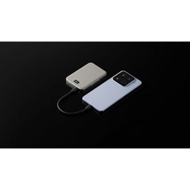 Hõbedane Solid Smile akupank ühendatud USB-C kaabliga helesinise telefoniga